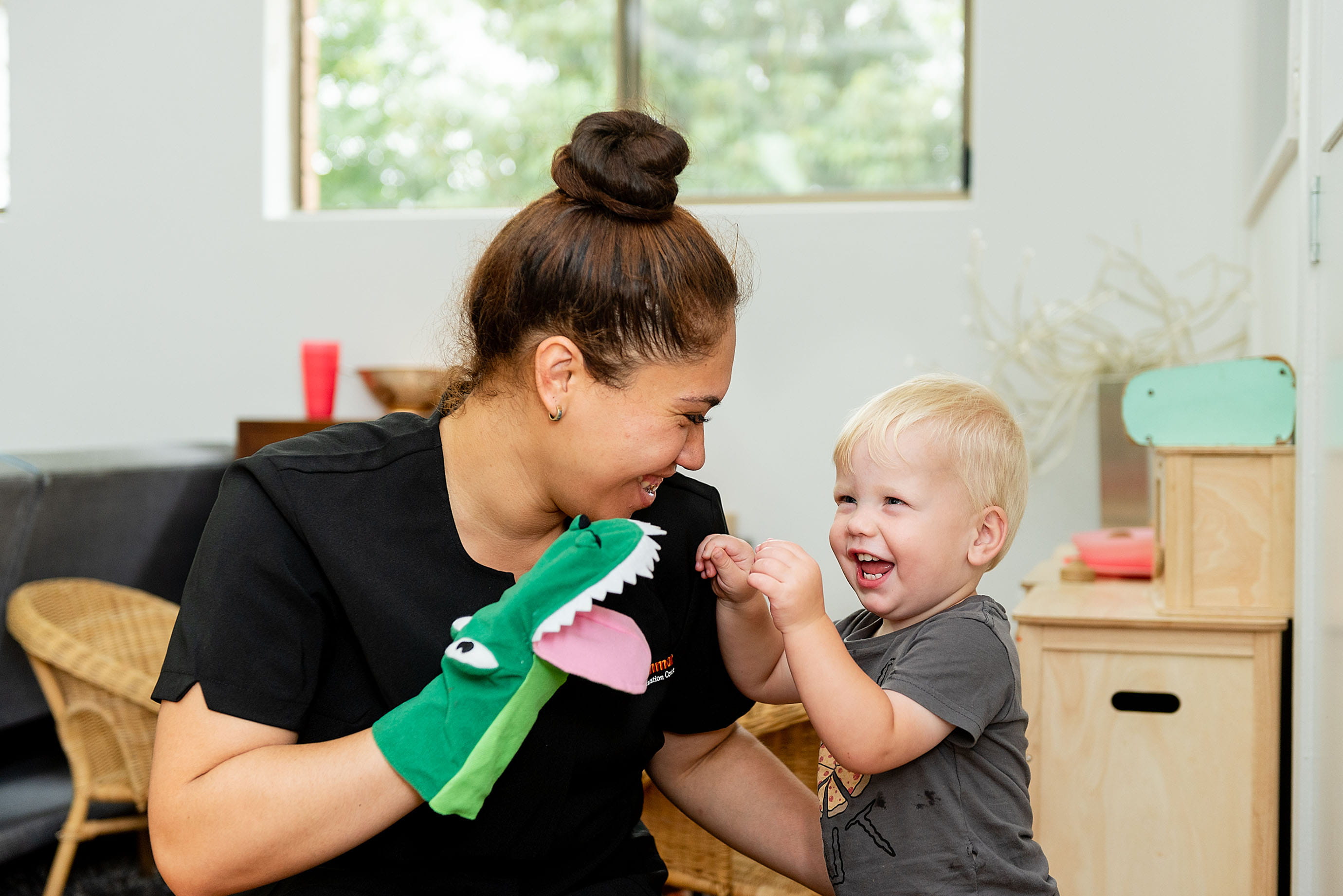 Educator and boy playing with hand puppet