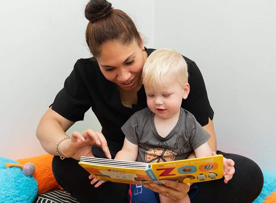 First Grammar learning program, day care educator teaching toddler how to read